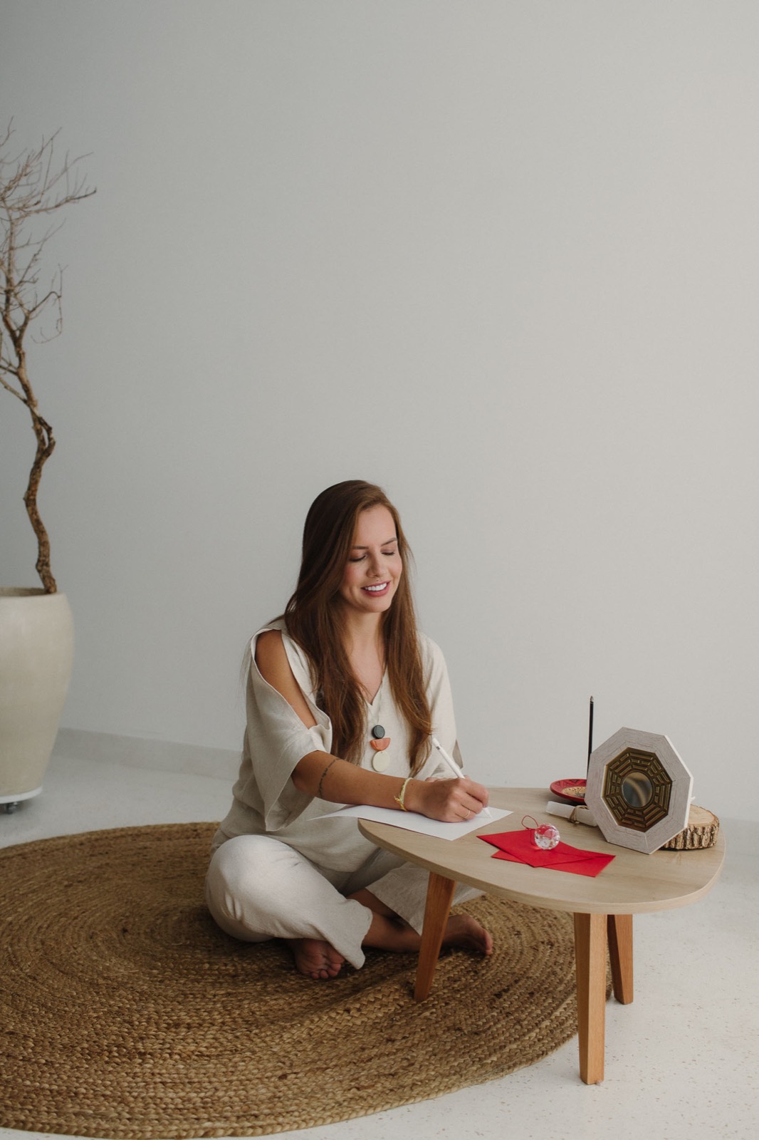 Bruna Veiga escrevendo à mesa em um ambiente claro